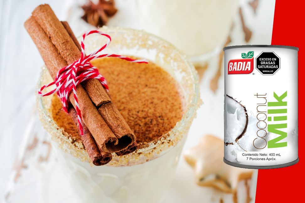 En un vaso escarchado con azúcar y canela, hay ponche de Navidad, preparado con Leche de Coco Badía